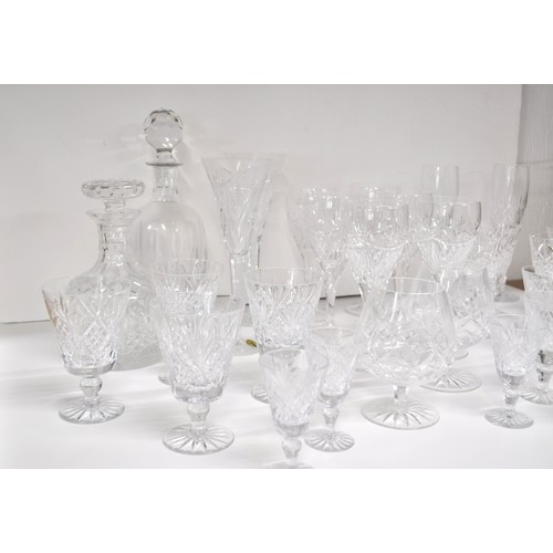 128 - A large quantity of mixed cut crystal glassware including a pair of Waterford Crystal champagne toas... 