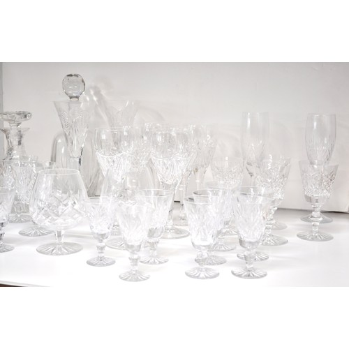 128 - A large quantity of mixed cut crystal glassware including a pair of Waterford Crystal champagne toas... 