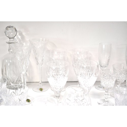 128 - A large quantity of mixed cut crystal glassware including a pair of Waterford Crystal champagne toas... 