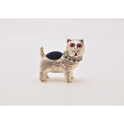 143 - A silver dog pin cushion with emerald collar and ruby eyes, stamped Sterling to base