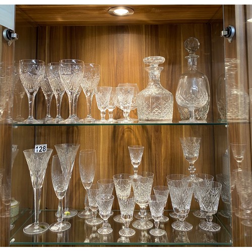 128 - A large quantity of mixed cut crystal glassware including a pair of Waterford Crystal champagne toas... 