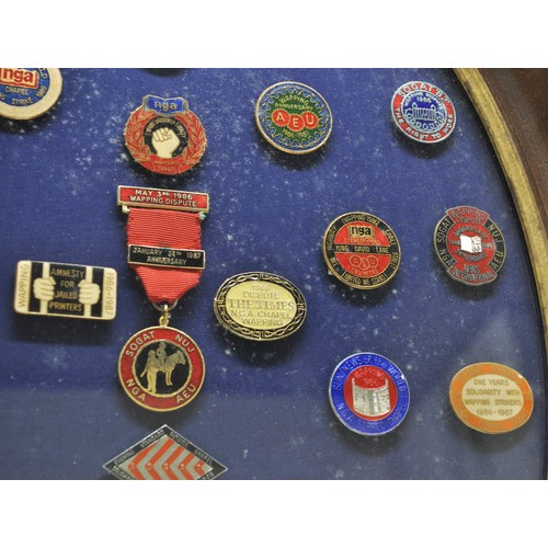 86 - Social History related pin badges displayed in oval glazed frame