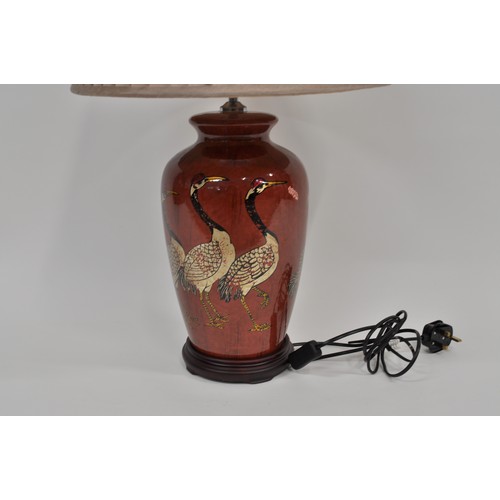 132 - Large table lamp with shade decorated with cranes upon a red circular base, DAR, approx. max includi... 