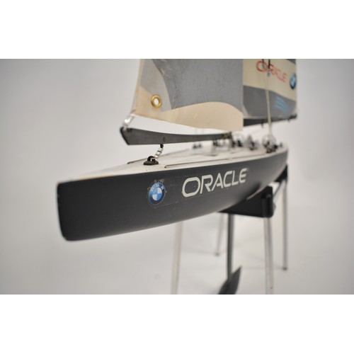 164 - A Scale Model Of The Oracle Racing Yacht, on stand and with a Kyosho Perfex controller