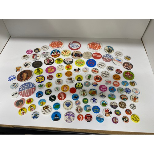 148 - A large collection of pin badges mixed themes to include pop, music, UK attractions,  merchandise ad... 