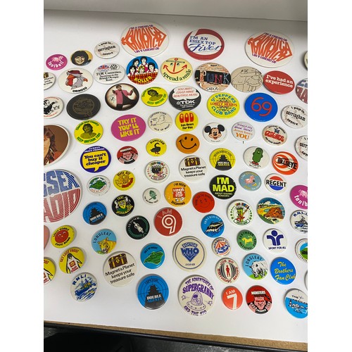 148 - A large collection of pin badges mixed themes to include pop, music, UK attractions,  merchandise ad... 