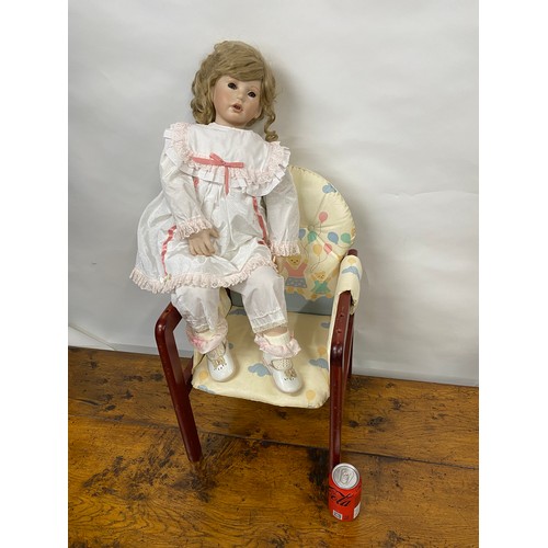 201 - Hand made doll with porcelain limbs and face, in seated pose, chair is also included.