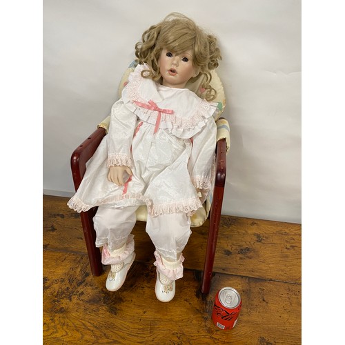 201 - Hand made doll with porcelain limbs and face, in seated pose, chair is also included.