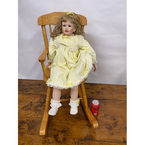 202 - Hand made doll with porcelain head and limbs, removable hair piece, also comes with wooden rocking c... 