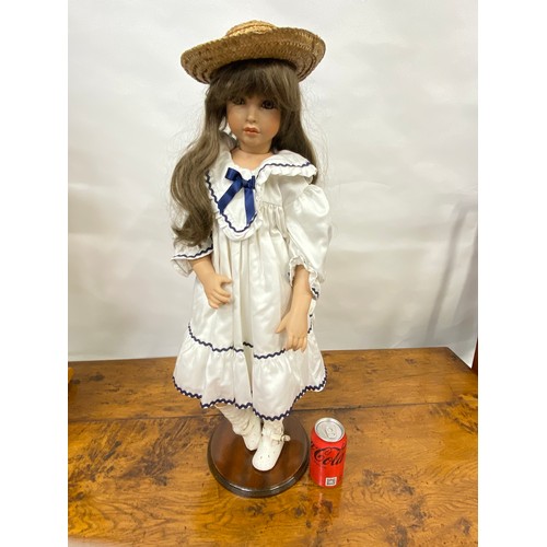 203 - Doll with porcelain head and limbs, with straw boater hat and removable stand, approx H74cm