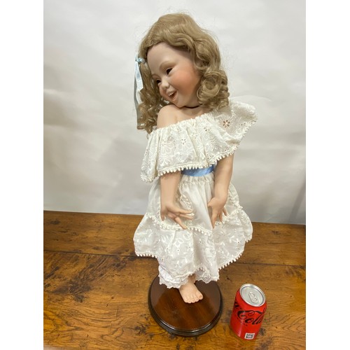 204 - Hand made doll on stand, porcelain face and limbs, cheeky expression to face with removable hairpiec... 