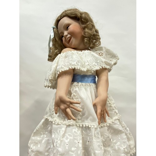 204 - Hand made doll on stand, porcelain face and limbs, cheeky expression to face with removable hairpiec... 