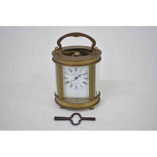 186 - Small French carriage clock retailed by Elliott & Son, London and contained in a glazed brass oval c... 