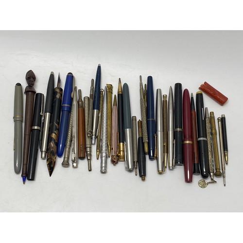 49 - A collection of fountain pens and pencils, including a Parker pen with 14k gold nib.