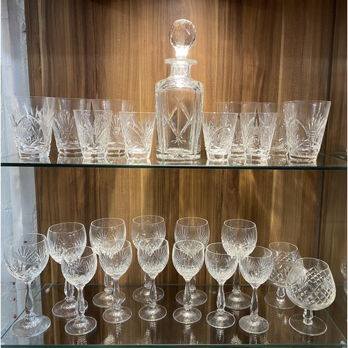 136 - Two shelves full of cut crystalware, to include a faceted decanter with mixed wine goblets and other... 