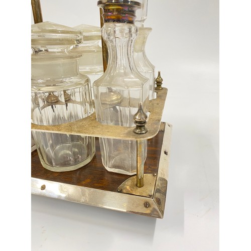 244 - Antique 6 bottle cruet set in oak and plated frame carrier