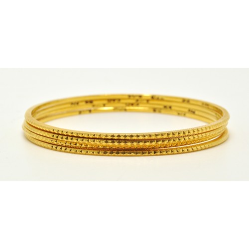 295 - Yellow gold bangles of same diamond cut design (x4) marked 22K. Total gross combined weight 33g.