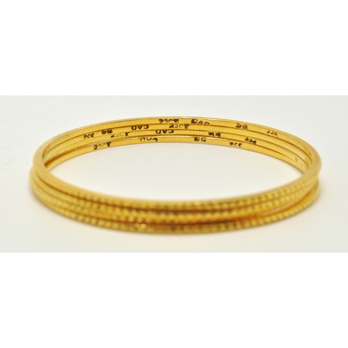 295 - Yellow gold bangles of same diamond cut design (x4) marked 22K. Total gross combined weight 33g.