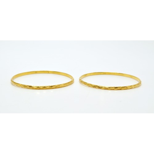 296 - Yellow gold bangles of same design, stamped 22K, approx combined gross weight 22.5g.