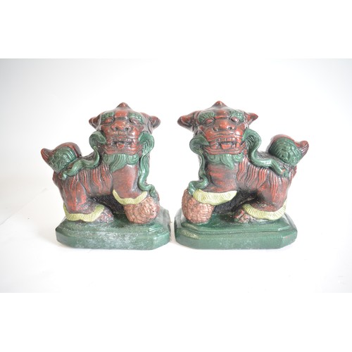 38 - A pair of heavy cast stone foo dogs with hand painted decoration approx H25cm x L25cm