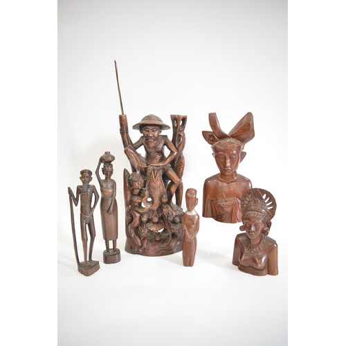 52 - A group of hand carved figures to include Asian, Balinese and African items