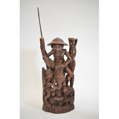 52 - A group of hand carved figures to include Asian, Balinese and African items