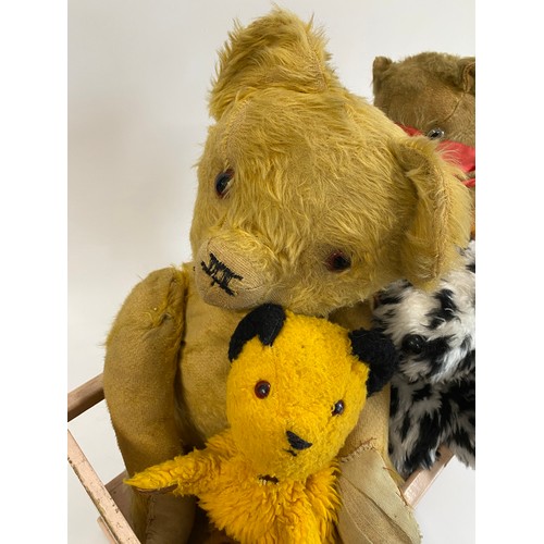 104 - A vintage cot containing Vintage pre-loved Teddy Bears, & two hand puppets