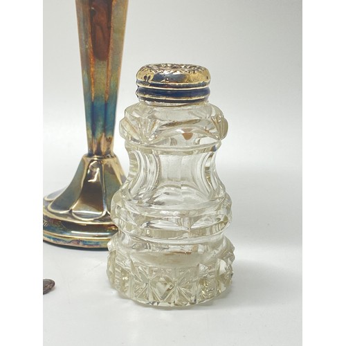 44 - Silver Interest - A silver trumpet vase together with cut glass salt and peppers,  Peperette, and sp... 