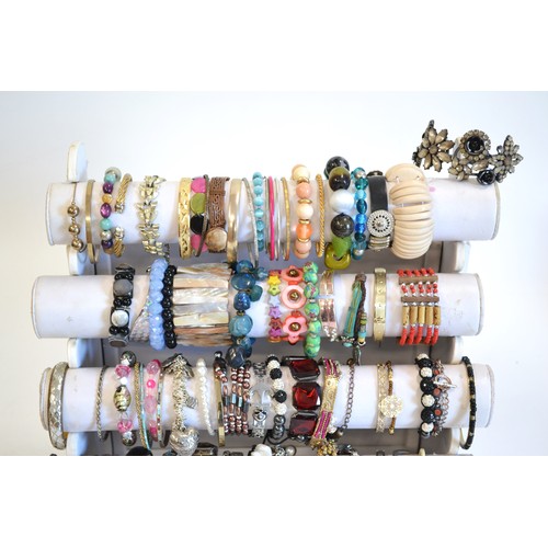 110 - Display stand [not included] showing a very large variety of costume bracelets in various colours an... 