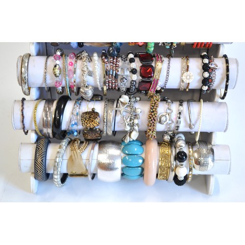 110 - Display stand [not included] showing a very large variety of costume bracelets in various colours an... 