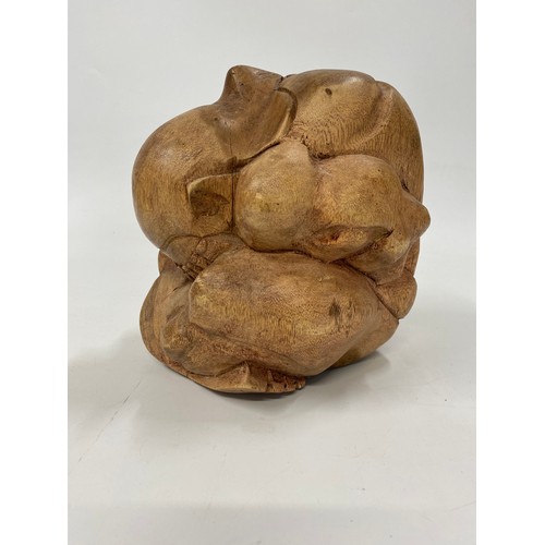 195 - A large hardwood crouching mythic figure with his head in his hands. H21cm