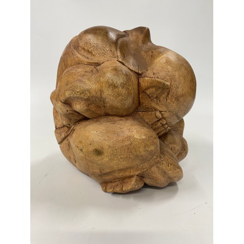 195 - A large hardwood crouching mythic figure with his head in his hands. H21cm