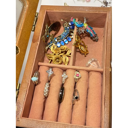 123 - A jewellery box containing a quantity of costume jewelry to include some silver items. Mixed necklac... 