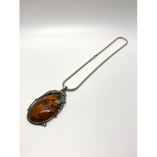 302 - Large silver amber pendant in art nouveau style on silver chain. Approx length of pendant 3