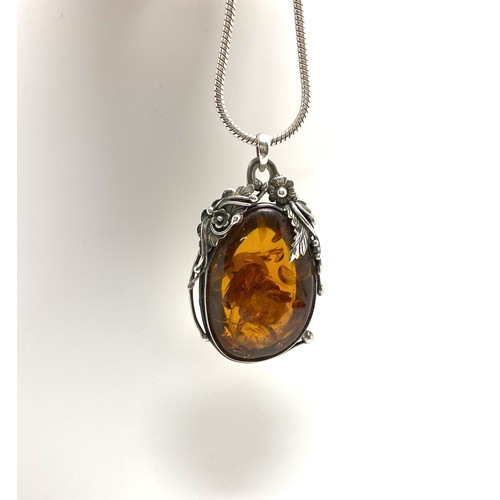 302 - Large silver amber pendant in art nouveau style on silver chain. Approx length of pendant 3