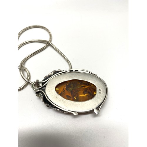 302 - Large silver amber pendant in art nouveau style on silver chain. Approx length of pendant 3