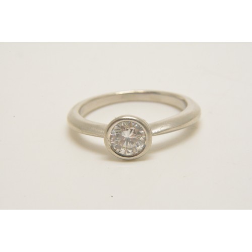 313 - Platinum solitaire ring set with a round brilliant cut diamond in a rub over setting, diamond weight... 