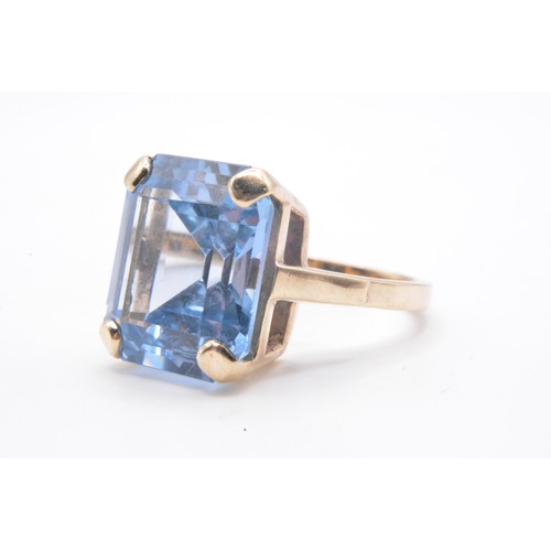 316 - 9ct yellow gold ring with emerald cut large blue stone in raised mount,  hallmarked London, approx s... 