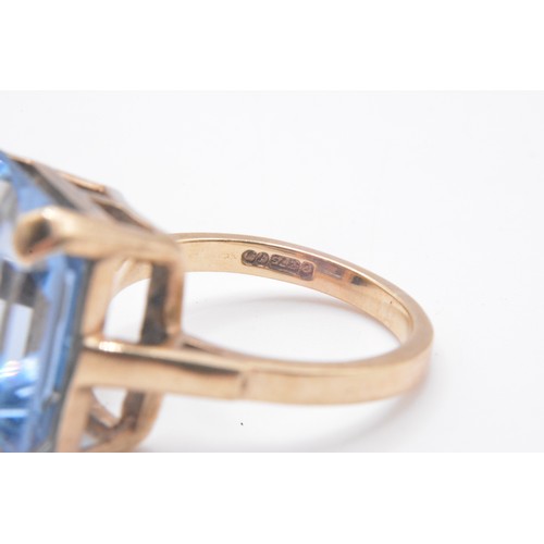 316 - 9ct yellow gold ring with emerald cut large blue stone in raised mount,  hallmarked London, approx s... 