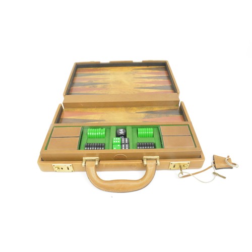 Vintage portable Gucci backgammon case/game. Tan leather with Burl wood on front and back of case and Burl wood game board/playing surface. 15 green and 15 black backgammon counters with double G Gucci logo in gold. Two sets of dice, one doubling cube and two leather shakers/cups. Green felt inset to lift out tray. Brass clasps on case marked Gucci.