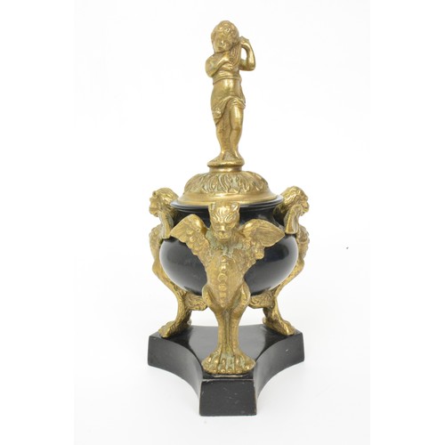 27 - Bronzed and slate figurine of cherub guarded by winged dragons, height 24cms