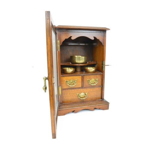 53 - Smokers cabinet, Oak cased with bevelled glass to front panel with two over one drawers with brass b... 