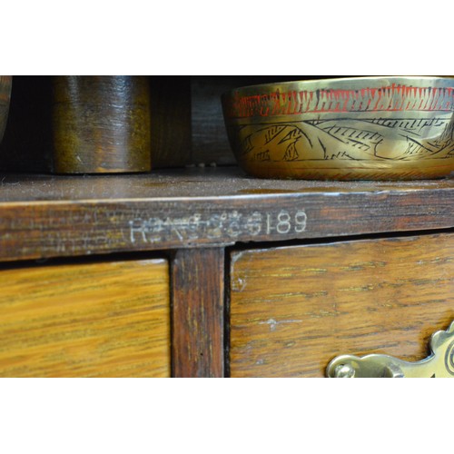 53 - Smokers cabinet, Oak cased with bevelled glass to front panel with two over one drawers with brass b... 