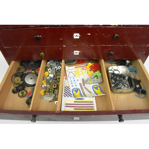 82 - Early Meccano 6 drawer cabinet  containing a large quantity of accessories and stickers and mixed in... 