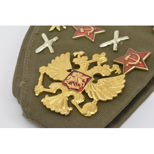 140 - Russian Military Cap with assortment of various metal badges.