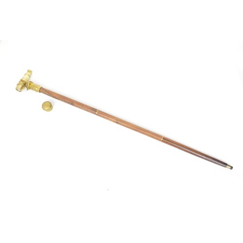 142 - A vintage walking stick with a brass horse's head handle which unscrews to reveal a small brandy or ... 