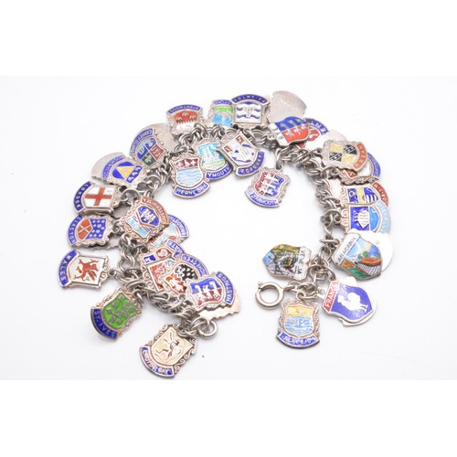 155 - Silver link bracelet with tourist charms stamped silver, approx. gross weight 65.55g