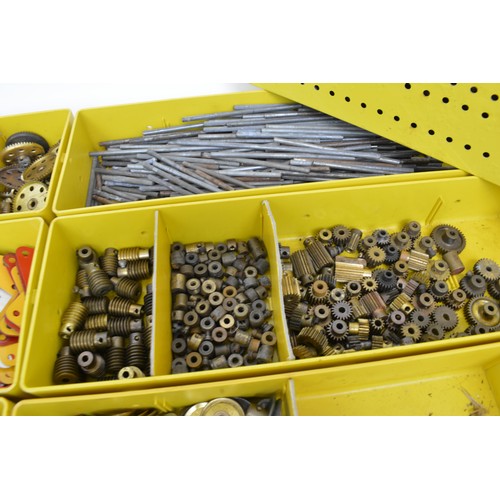 Yellow Meccano storage tins containing mixed components, cogs, trunions ...