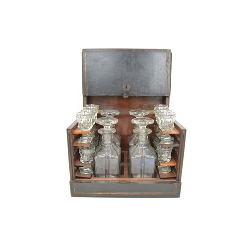 7 - Antique Liqueur Tantalus, ebonised wooden case which opens up to reveal sixteen glasses and  four ca... 