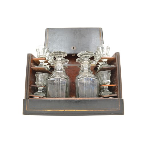 7 - Antique Liqueur Tantalus, ebonised wooden case which opens up to reveal sixteen glasses and  four ca... 